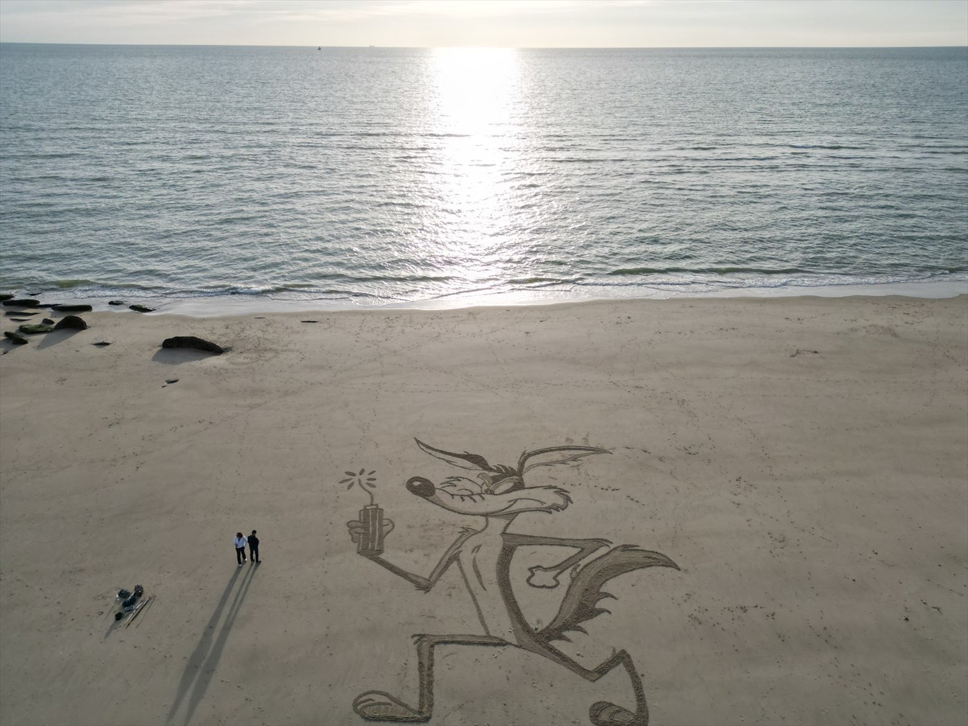 Grande fresque figurative tracée sur le sable face à la mer